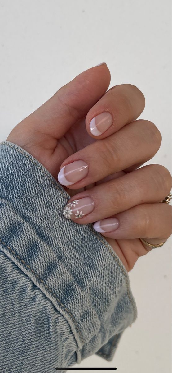 Sophisticated Nude Nail Design with French Tips and Floral Accents.