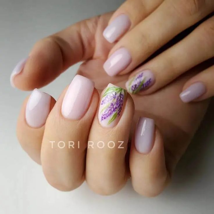 Refined Feminine Nail Design: Pale Pink Base with Whimsical Floral Accent.