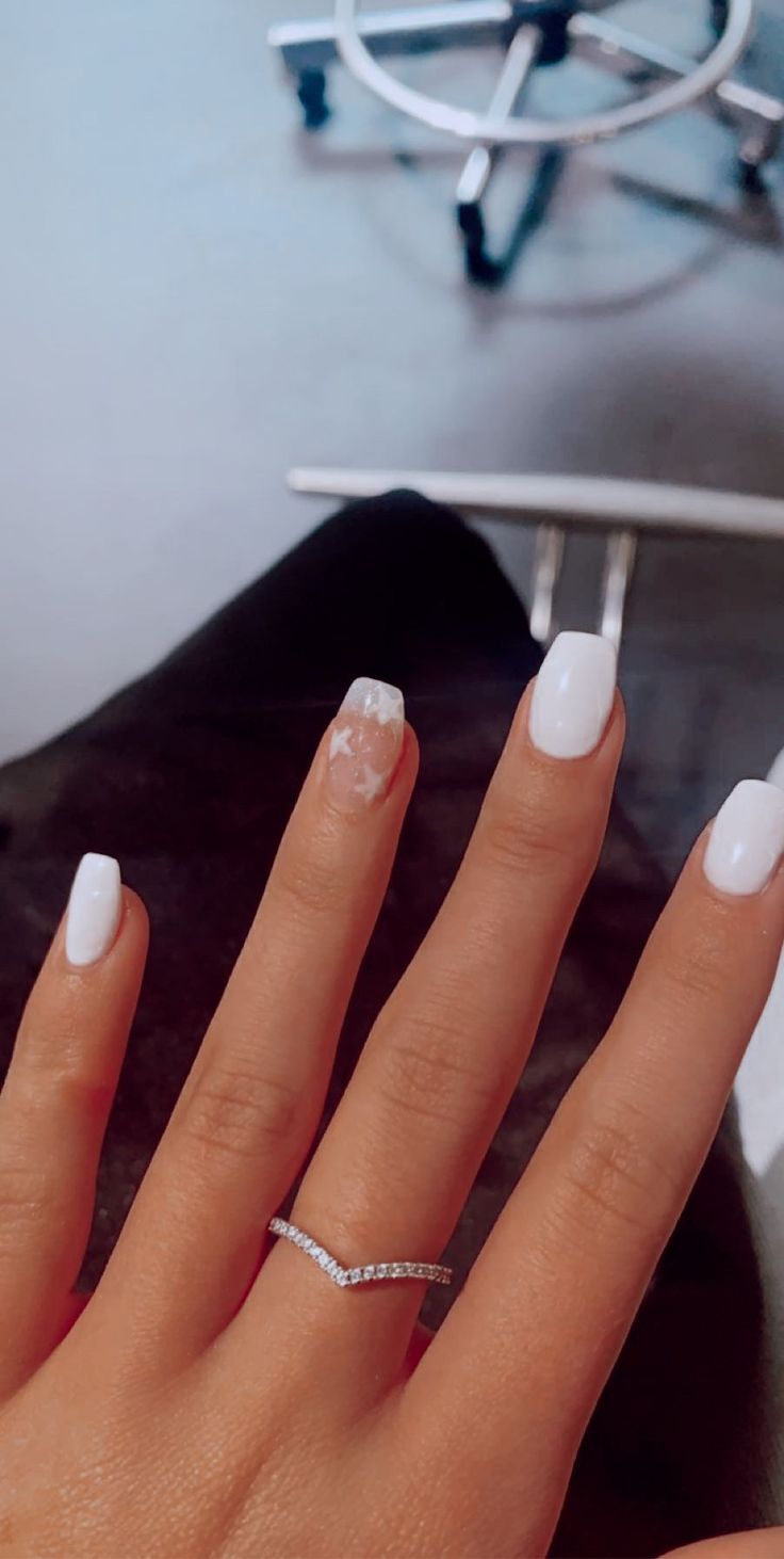 Sleek White Nail Design with Artful Accents and Sophisticated Touches.