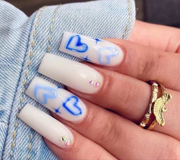 Trendy Chic Nail Design: Glossy White with Blue Heart Outlines and Sparkling Rhinestones.