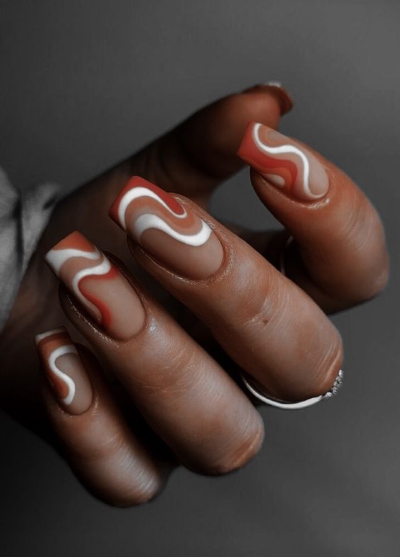 Chic Nail Design with Earthy Tones and Elegant Swirls.