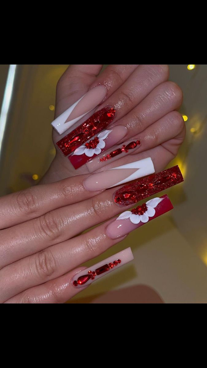 Bold Red and Elegant White Nail Design with Intricate Floral Accents and Glamorous Glitter.