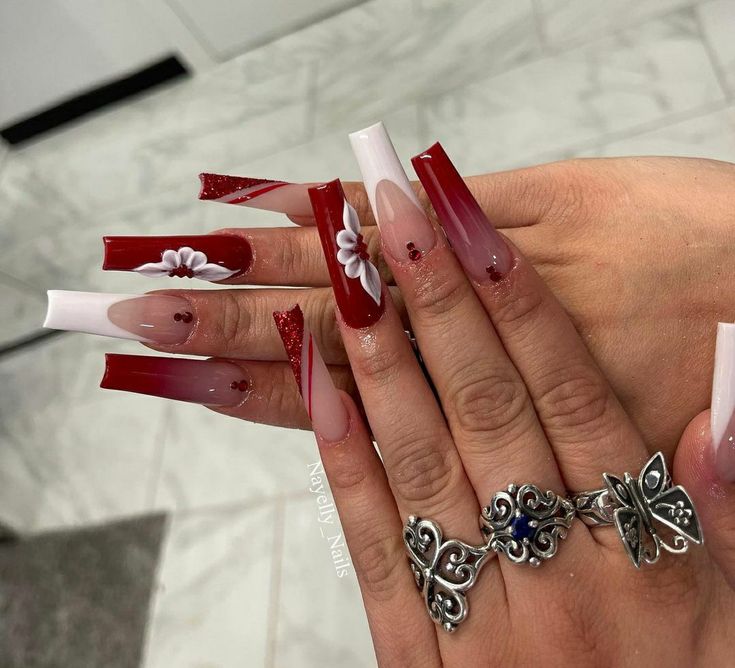 Elegant Ombre Red Nails with Floral Patterns and Glitter Accents