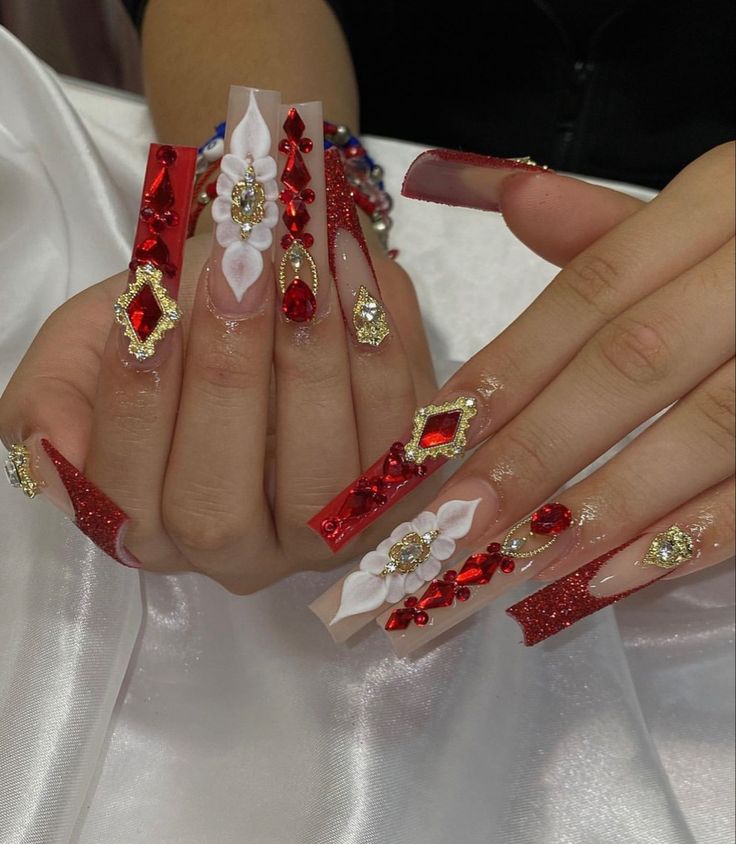 Glamorous Long Nail Design with Red, Clear Elements, Gems, and Floral Accents.