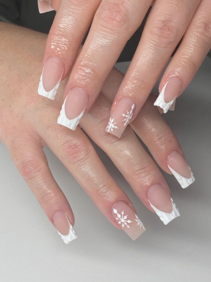 Elegant Nude and White Nail Design with Contemporary French Tips and Floral Accents.