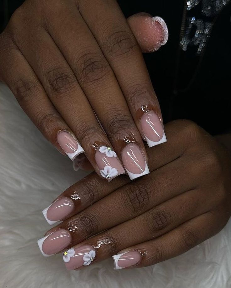 Elegant Soft Pink and White Tip Nail Design with Floral Accents.