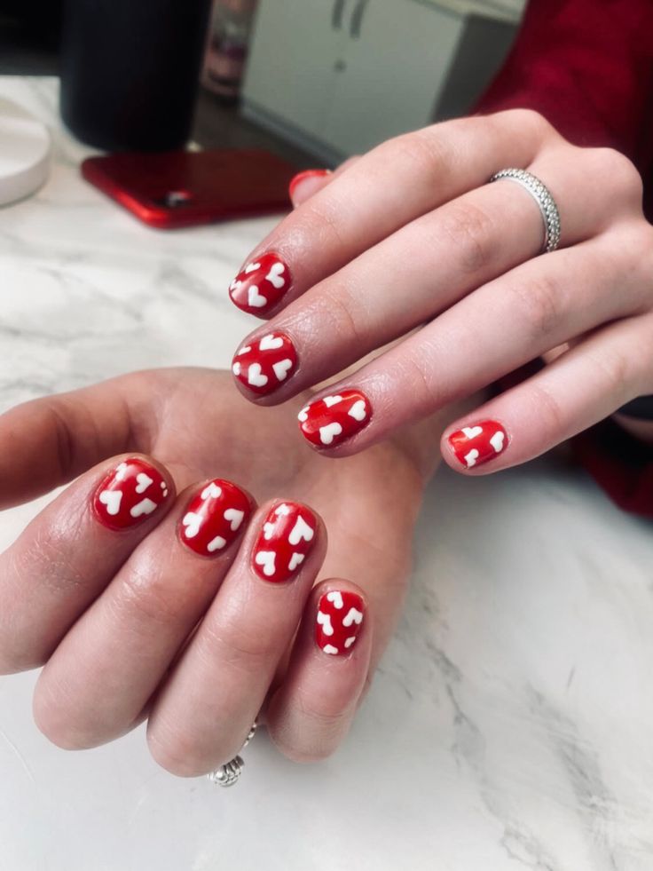 Festive Heart-Themed Nail Design: Bright Red Base with Playful White Accents for Everyday Romance.