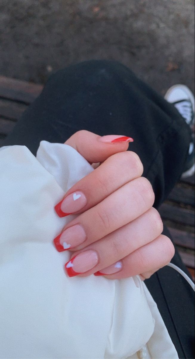 Chic Red Tip Nail Design with Playful White Heart Accents.