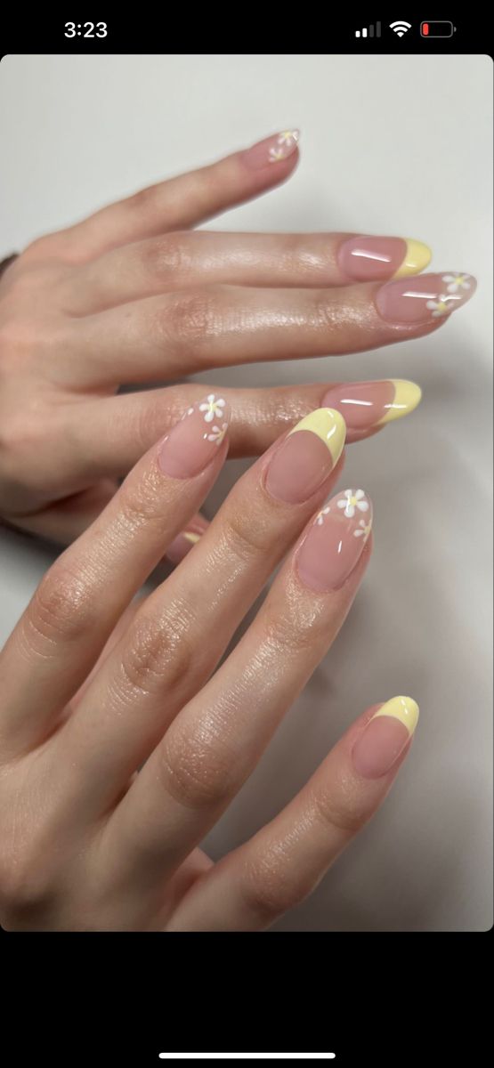 Cheerful Spring-Inspired Nail Design: Soft Pink Base with Yellow Tips and Floral Accents.