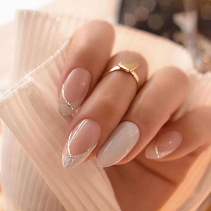 Elegant Almond-Shaped Nails with Soft Nude Base, Light Blue Accent, and Silver Lines for a Sophisticated Look.