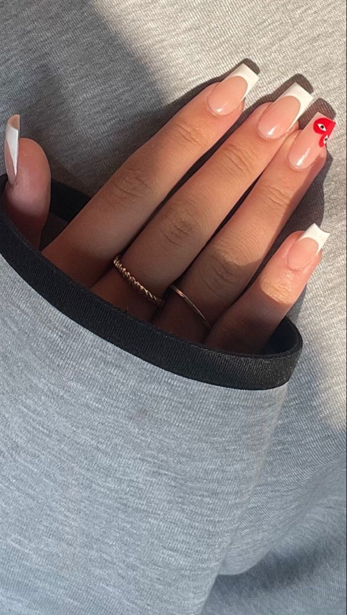 Chic Modern French Tip Nail Design with Playful Red Accent.