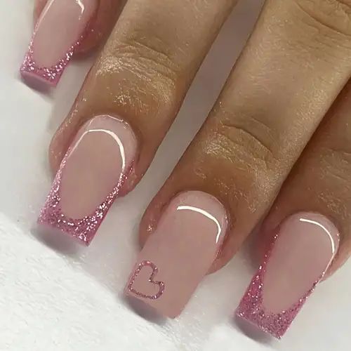 Elegant Soft Pink Nail Design with Glitter Tips and Heart Accents.