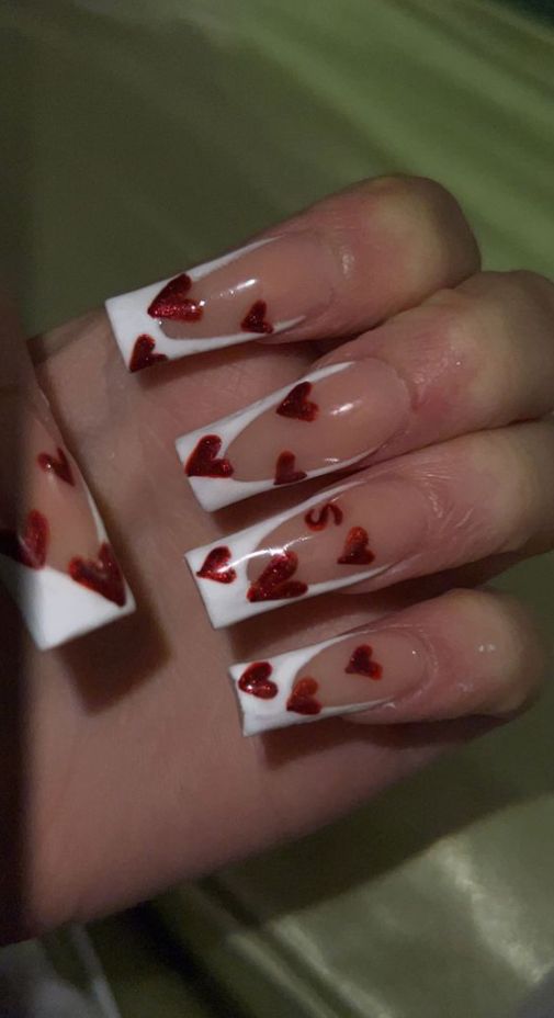 Charming Vibrant Nail Design: White Tips, Natural Polish, and Sparkling Red Hearts for Romantic Flair.