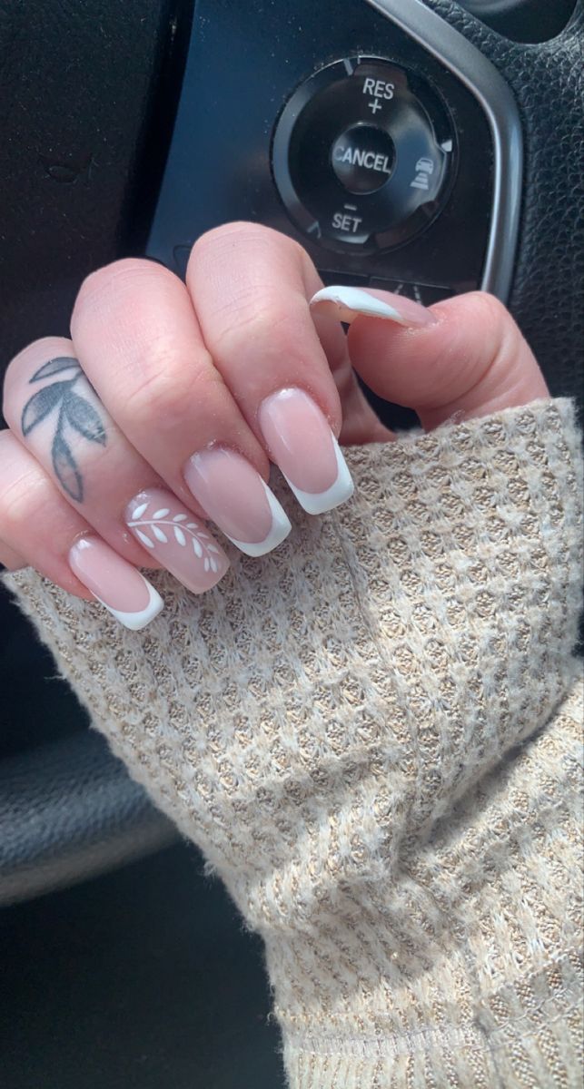 Sophisticated French Manicure with Leaf Accent: A Stylish Twist.