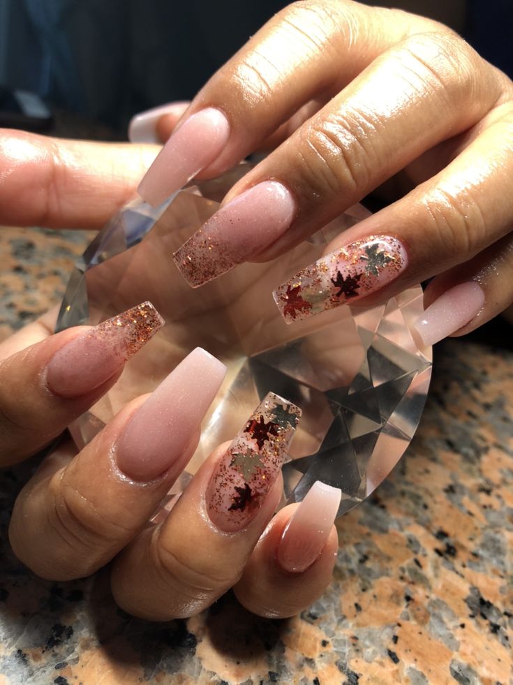 Chic Nail Design: Elegant Nude with Glitter and Delicate Leaf Patterns