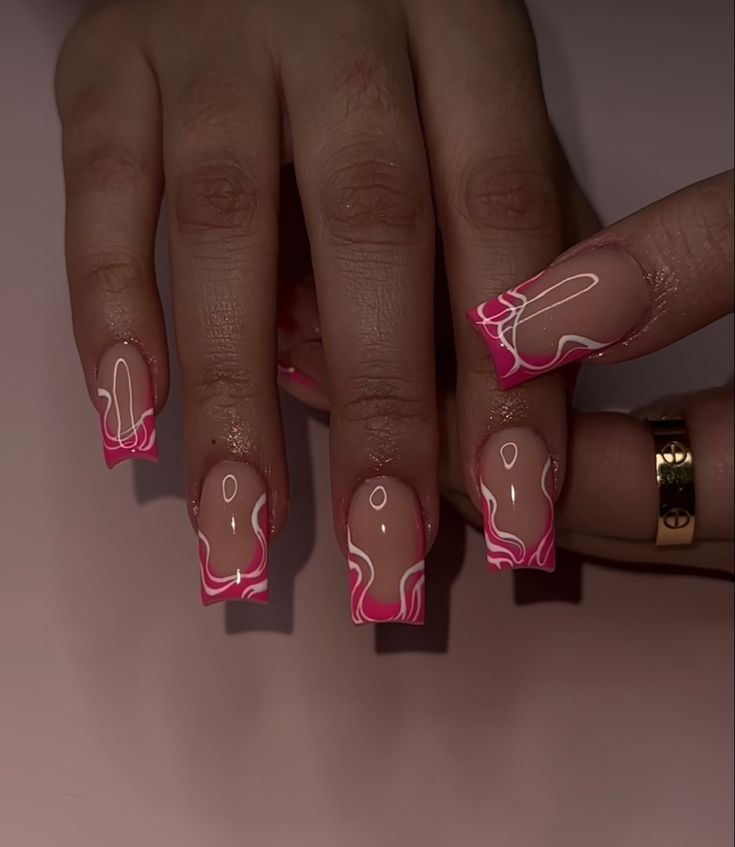 Elegant Stylish Nail Design: Nude Base with Vibrant Pink Accents and Fluid Marble Tips.