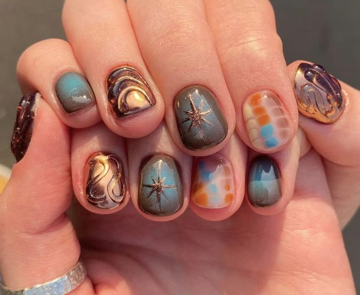 Cosmic-Inspired Vibrant Nail Art: A Stunning Blend of Colors, Patterns, and Sparkling Star Accents.