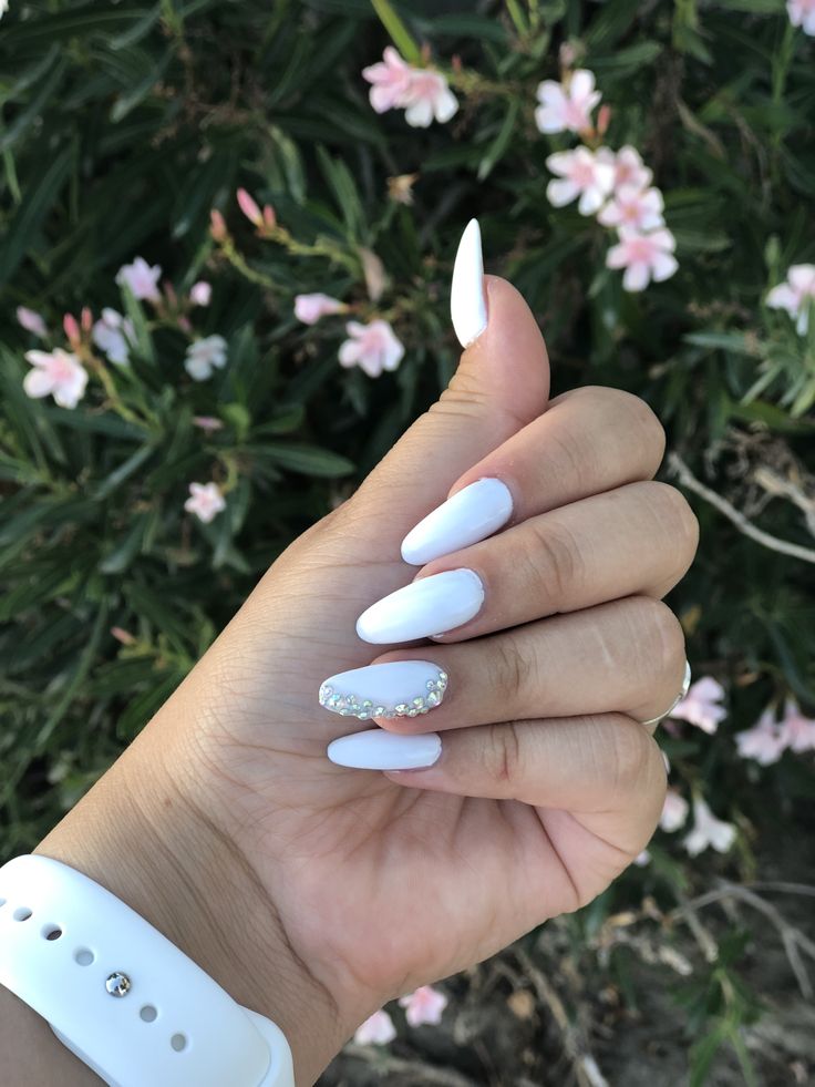 Chic Almond-shaped Pastel Blue Nails with Rhinestone Accent: A Fresh Spring Aesthetic.