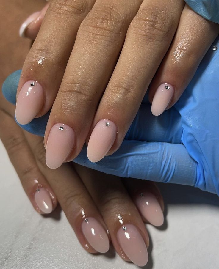 Sophisticated Nude Pink Nail Design with Rhinestones and Tapered Almond Shape.