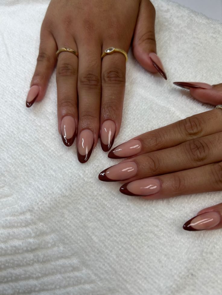 Chic Almond-Shaped Nails with Glossy Nude Base and Deep Burgundy Tips.