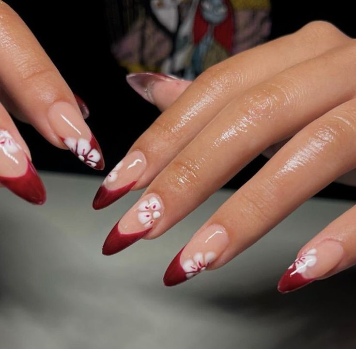 Sophisticated Red and Nude Nail Design with Floral Accents for Special Occasions.