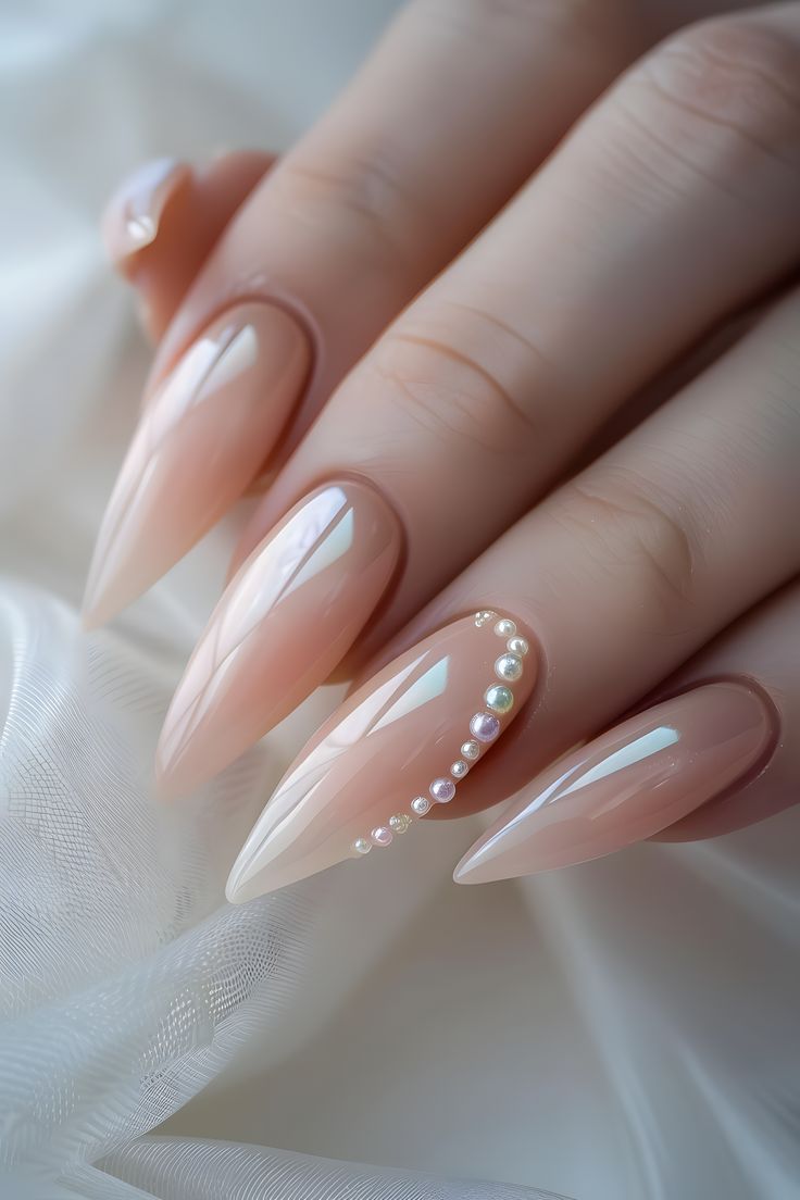 Sophisticated Gradient Nude and Pink Nail Design with Pearl Accents and Pointed Tips