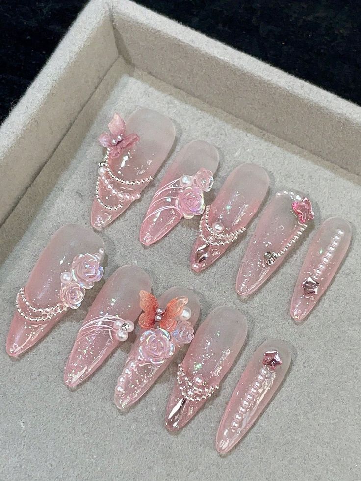 Charming Delicate Nail Design with Soft Pink Shades and Intricate Floral Embellishments.