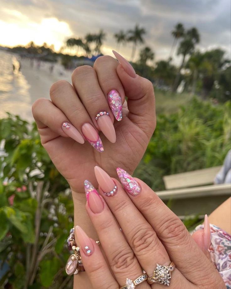 Chic Nail Design: Soft Pink Hues with Glitter and Rhinestone Accents.