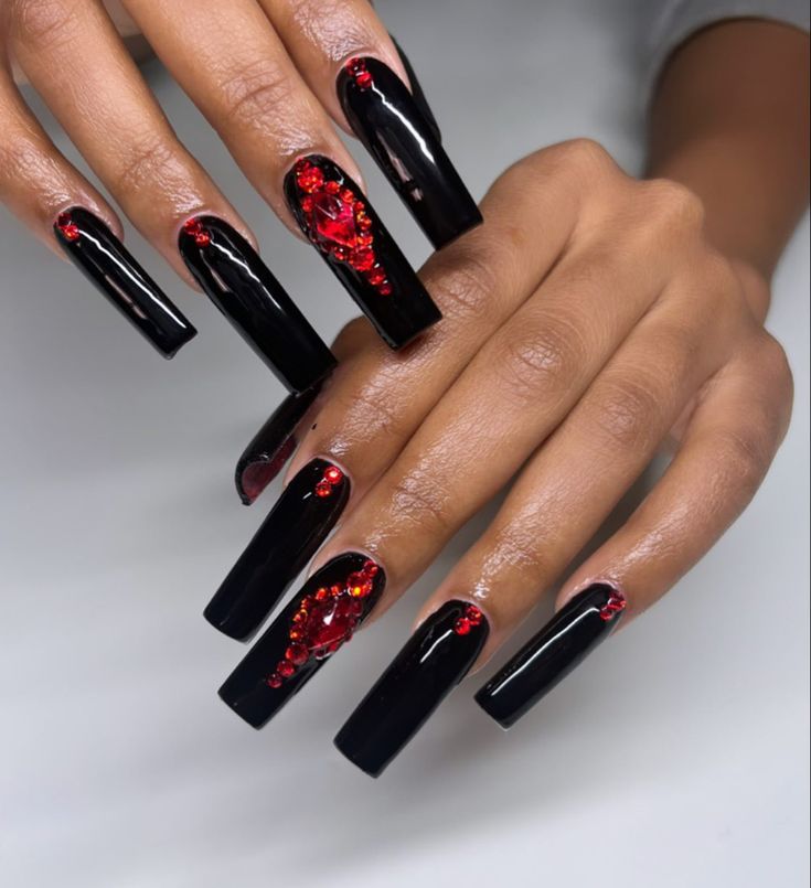 Elegant Black and Red Nail Design: Striking Long Nails with Dramatic Embellishments.