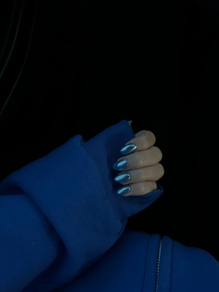 Elegant Shimmering Blue Nails Complemented by a Cozy Sweater for a Casual Chic Look.