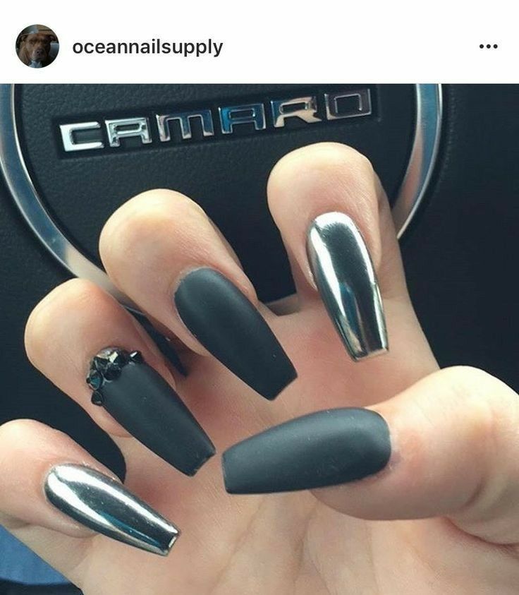 Chic Nail Design: Matte Black and Metallic Silver with Jewel Accent.