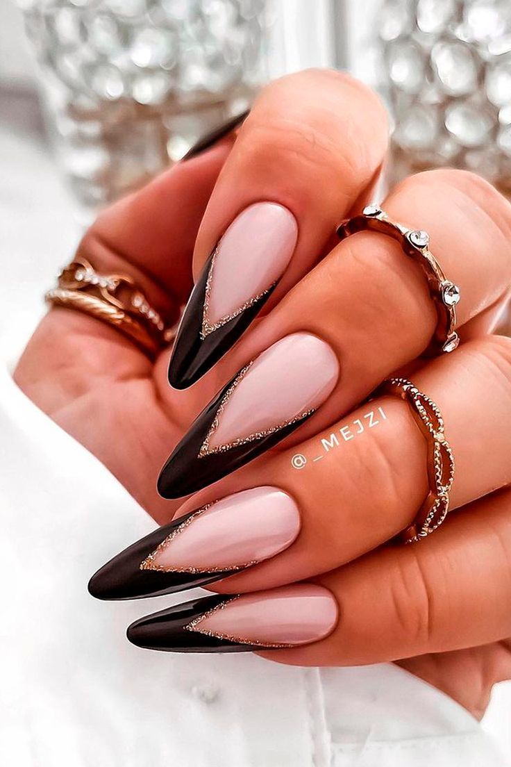 Chic Almond-Shaped Nail Design: Elegant Black and Nude with Gold Accents