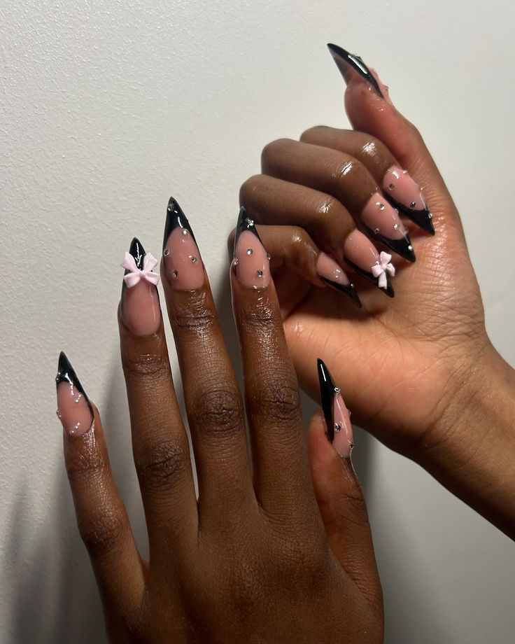 Chic Tapered Nail Design with Glossy Black Tips, Pink Base, Bows, and Rhinestones.