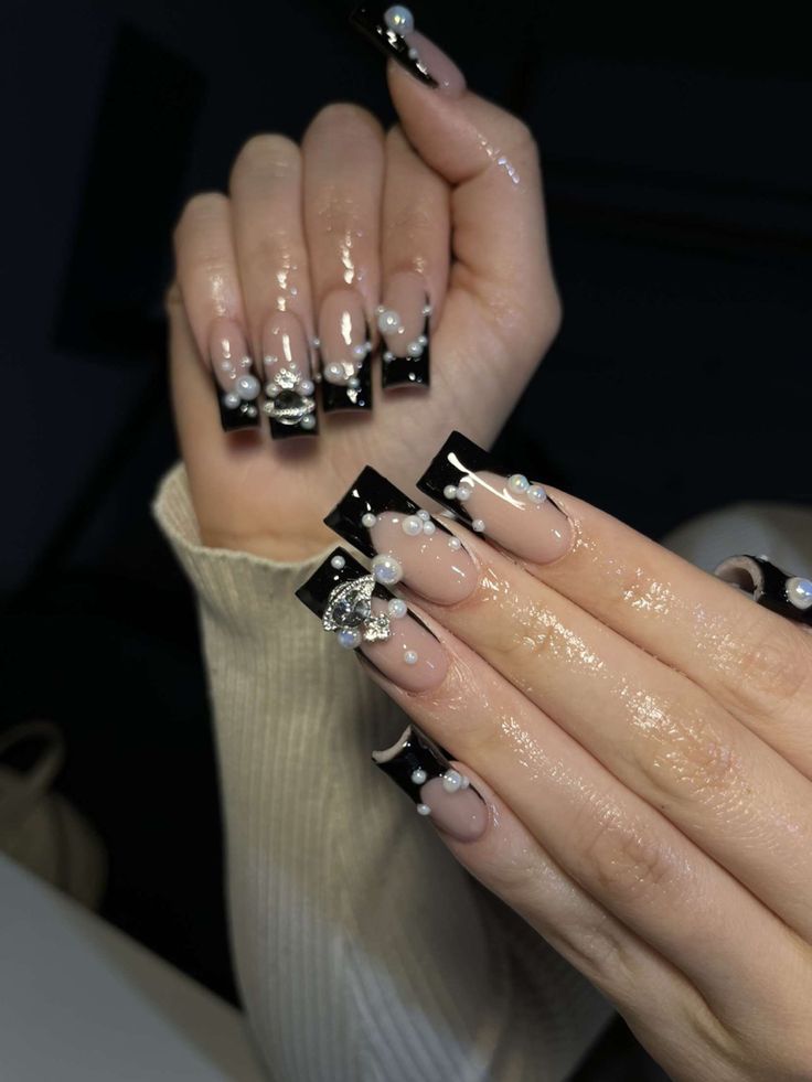 Sleek Nude and Black Gem-Embellished Nail Design for Glamorous Occasions.