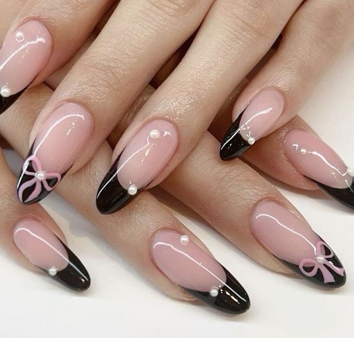 Chic Nude and Glossy Black Nail Design with Pearls and Pink Bows