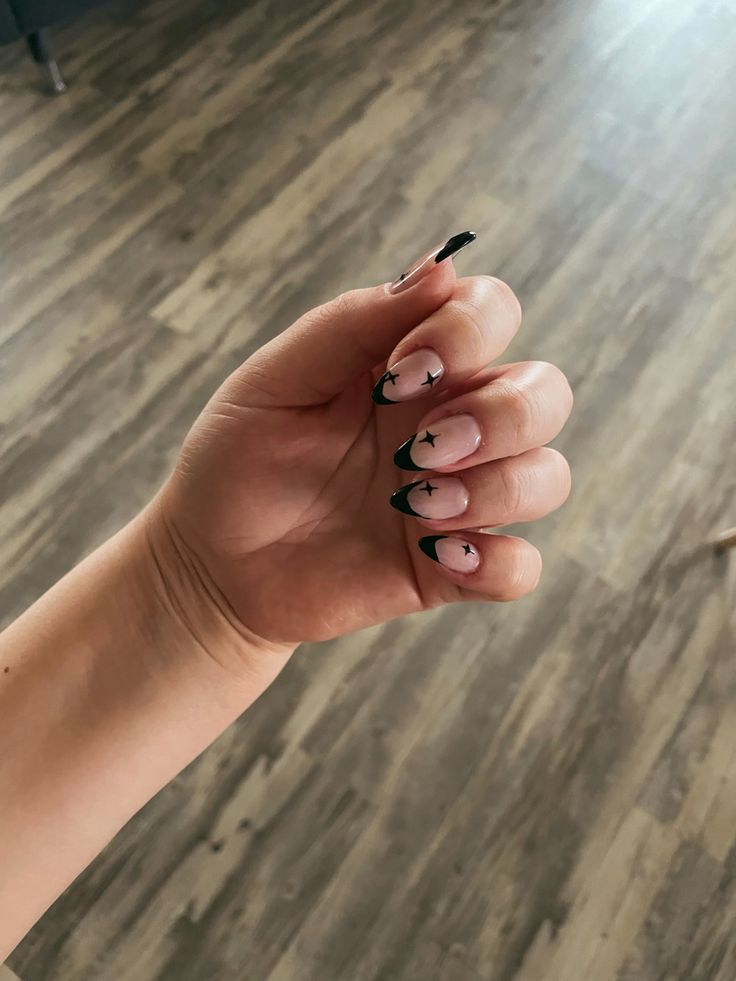 Chic Gradient Pink Nails with Bold Black Tips and Whimsical Star Motifs.