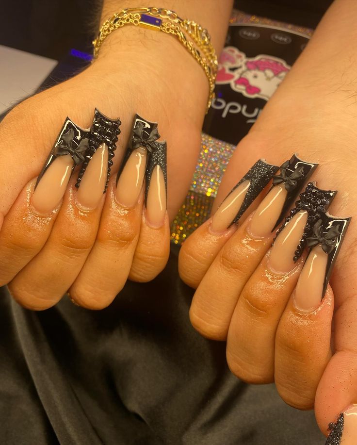 Edgy Elegance: Almond-Shaped Nude Nails with Glossy Black Accents and Sparkly Embellishments.