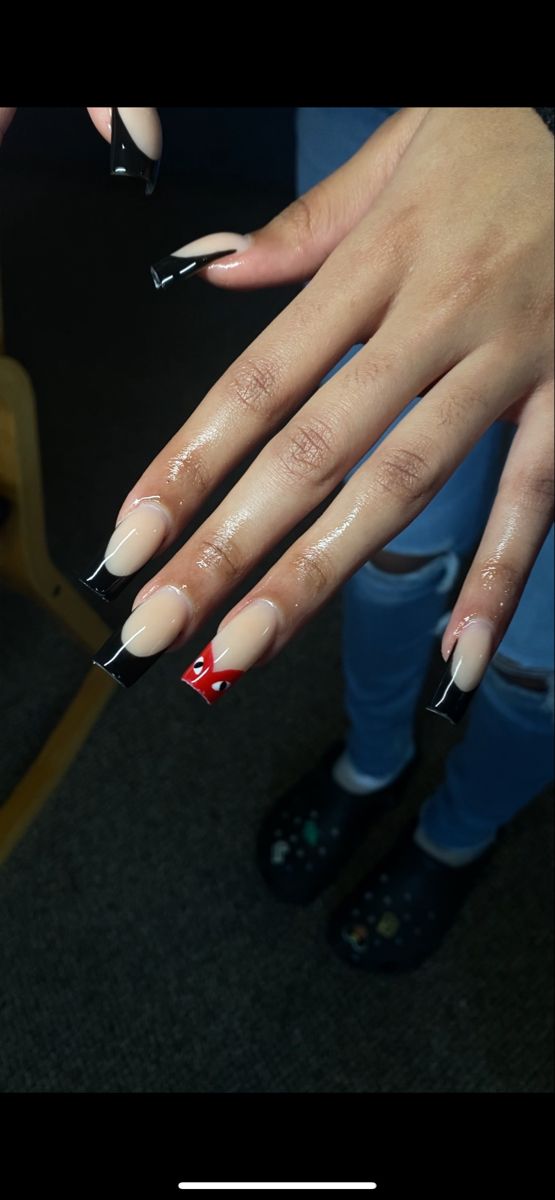 Sophisticated Nude and Bold Black Nail Design with Playful Red Accent.