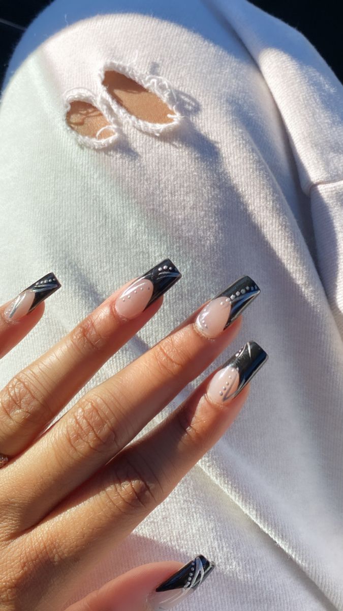 Elegant Nude and Bold Black Nail Design with Intricate Detailing and Shimmering Gems