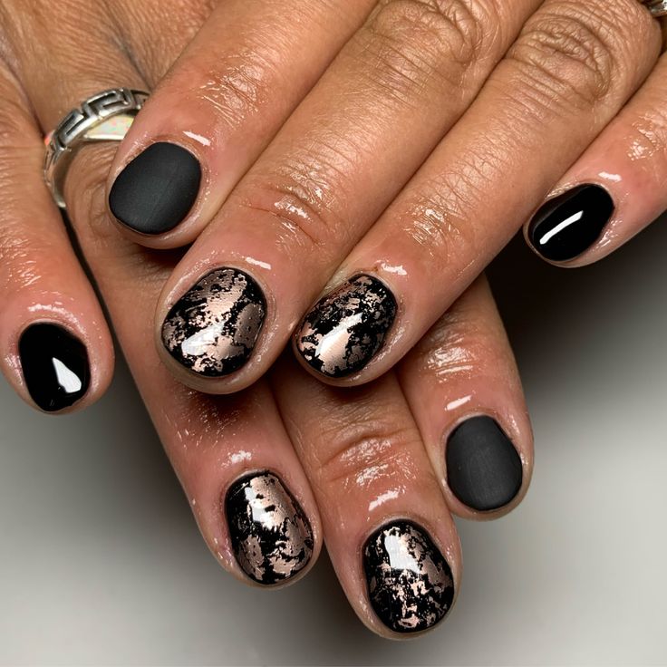 Chic Matte Black and Glossy Nail Design with Striking Marbled Metallic Accents