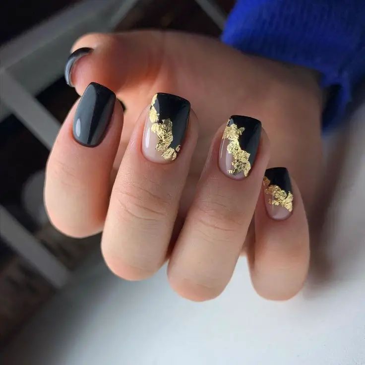 Sophisticated Black and Translucent Manicure with Luxurious Gold Foil Accents.