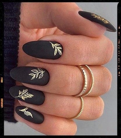 Chic Black Matte Nails with Gold Leaf Patterns for a Modern Elegant Look