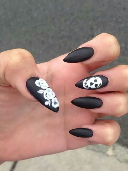 Bold Matte Black Nails with Intricate White Floral and Skull Designs for a Striking Gothic Look.