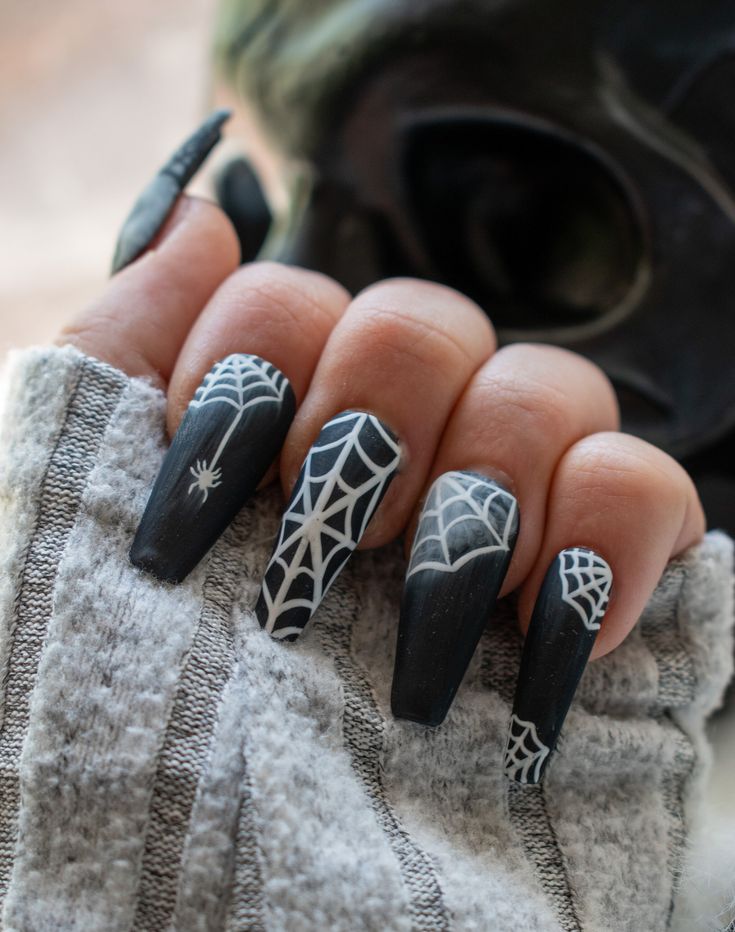 Gothic Nail Art: Angular Black Nails with White Spiderwebs and a Spider Accent for Halloween Flair.