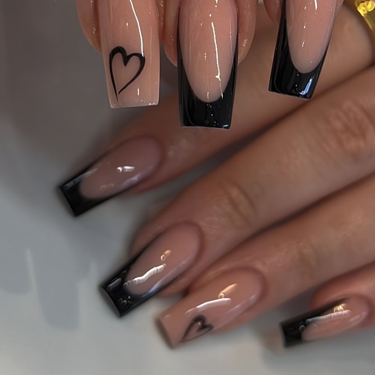 Elegant Nude and Black Nail Design with Romantic Heart Motifs.