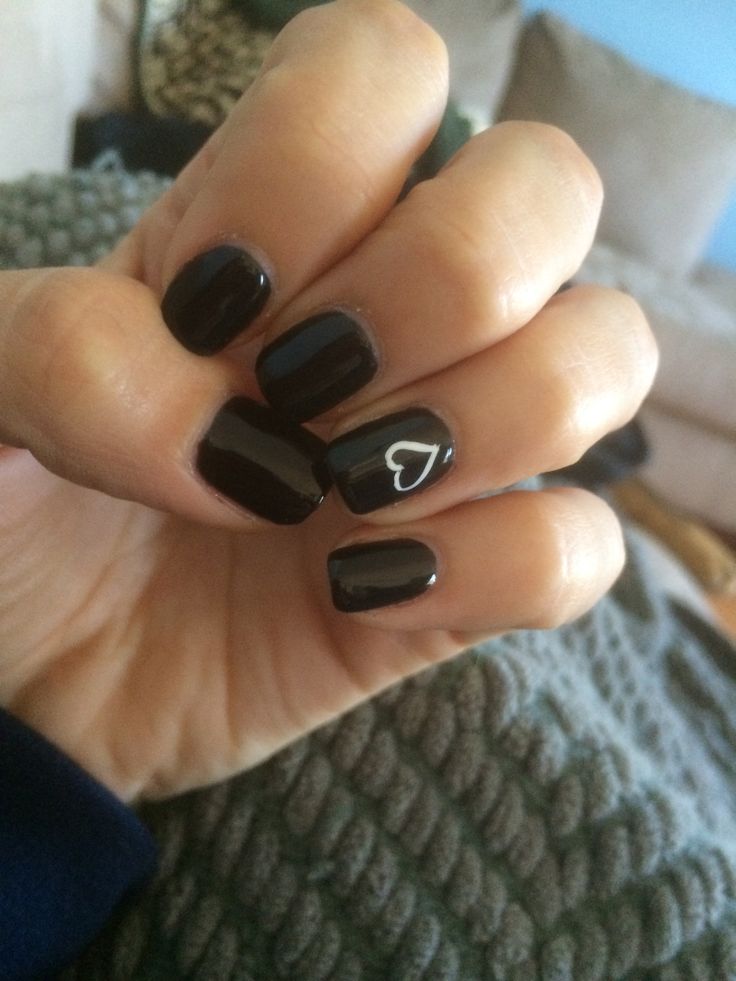 Chic Black Nail Design with Glossy Finish and Whimsical Heart Accent.