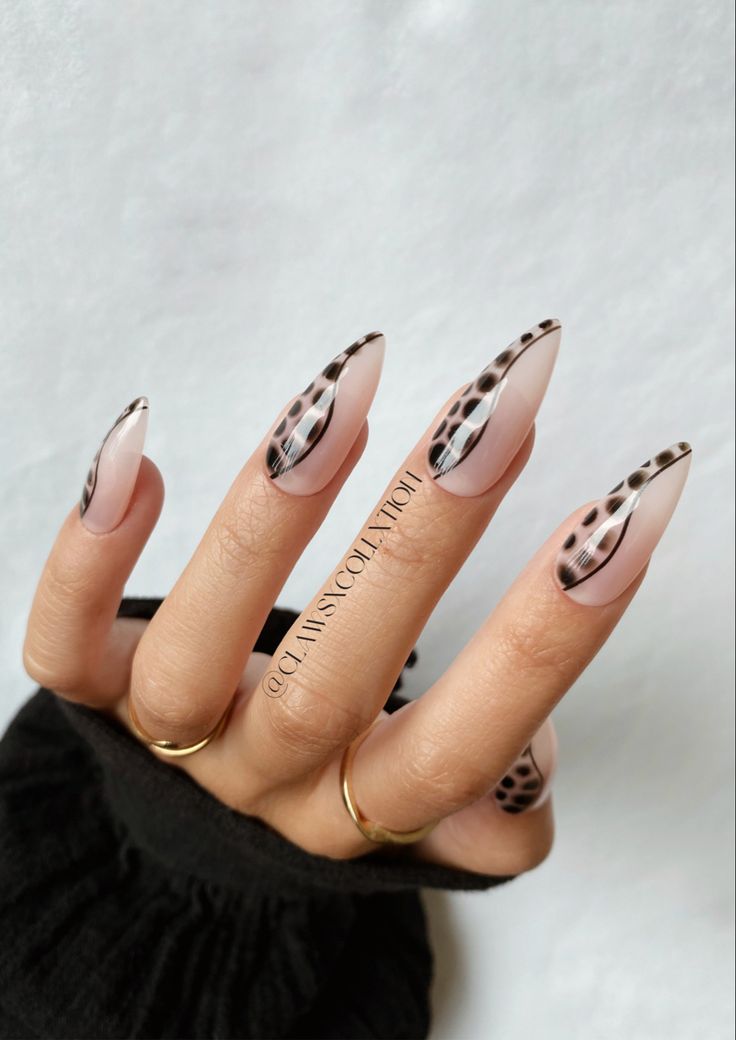 Chic Elegant Stiletto Nails Featuring Bold Black Patterns and Soft Nude with Geometric Design.