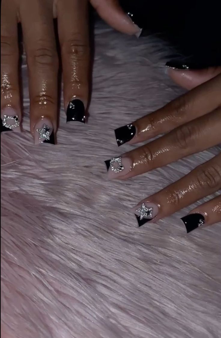 Chic Glamorous Nail Design with Glossy Black, Soft Nude, Silver Embellishments, and Star Motifs.