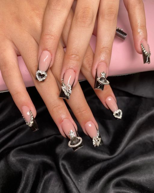 Elegant Manicure: Glamorous Nude and Glossy Black Nail Design with Intricate Embellishments