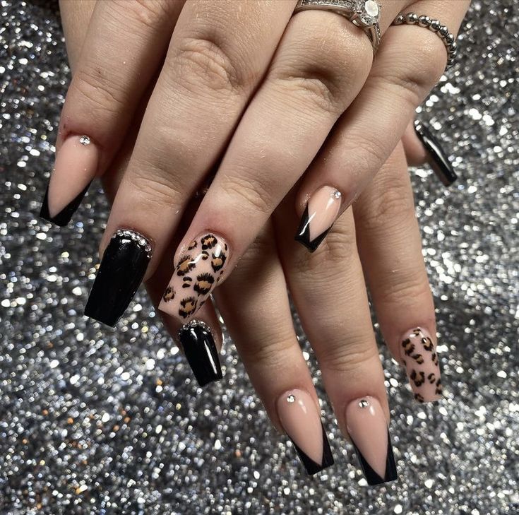 Chic Leopard Print Nail Design: Glamorous Gemstone Accents with Elegant Black and Nude Finishes.